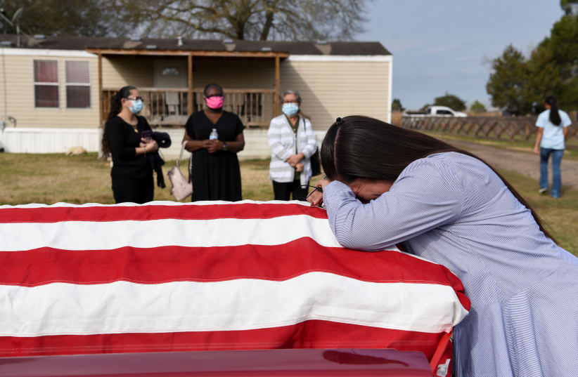 Lila Blanks reacts next to the casket of her husband, Gregory Blanks, 50, who died from complications from the coronavirus disease (COVID-19), ahead of his funeral in San Felipe, Texas, US, January 26, 2021. (photo credit: CALLAGHAN O'HARE/REUTERS)