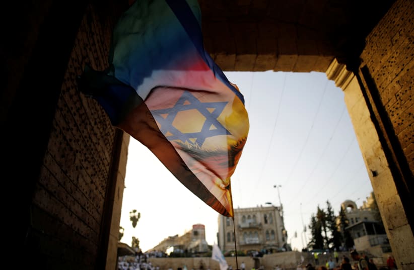 A Jewish youth waves a flag as he participates in a march marking "Jerusalem Day", near Damascus Gate in Jerusalem's Old City June 2, 2019.  (photo credit: REUTERS/AMIR COHEN)