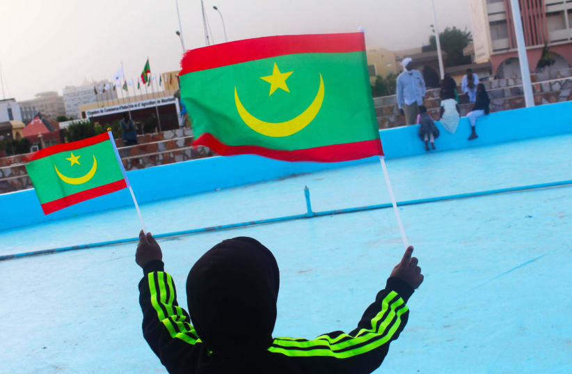 A young boy is seen waving Mauritanian flags. (photo credit: Wikimedia Commons)