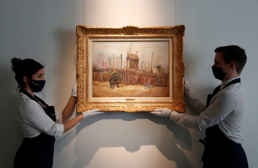 Sotheby's Paris employees pose with the 1887 painting of a Paris street scene "Scene de rue a Montmartre" by Dutch painter Vincent Van Gogh which will be presented to the public for the first time after spending more than a century behind closed doors in the private collection of a French family, Fr (photo credit: CHRISTIAN HARTMANN/REUTERS)