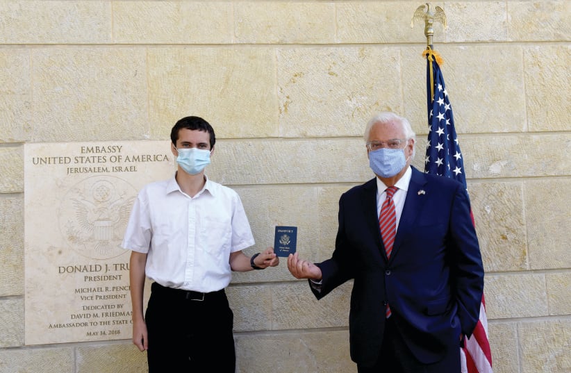 US Ambassador David Friedman presents Menachem Zivotofsky, with a passport (photo credit: DEBBIE HILL/REUTERS)