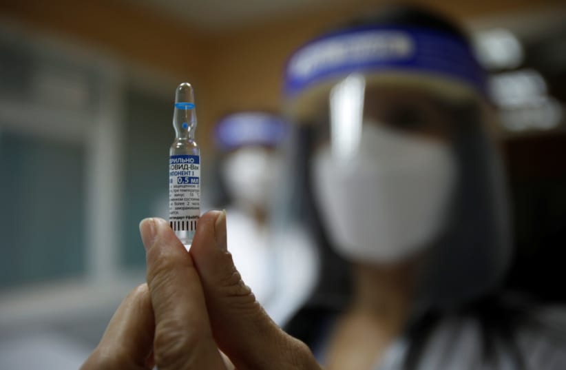 A healthcare worker shows an ampule with the Sputnik V coronavirus disease (COVID-19) vaccine in Podgorica, Montenegro, February 22, 2021. (photo credit: REUTERS)