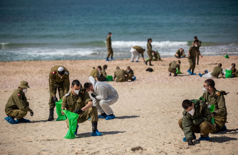 SOLDIERS CLEAN tar off Palmahim beach on Monday, following an offshore oil spill that drenched most of the Israeli coastline. (photo credit: YONATAN SINDEL/FLASH 90)