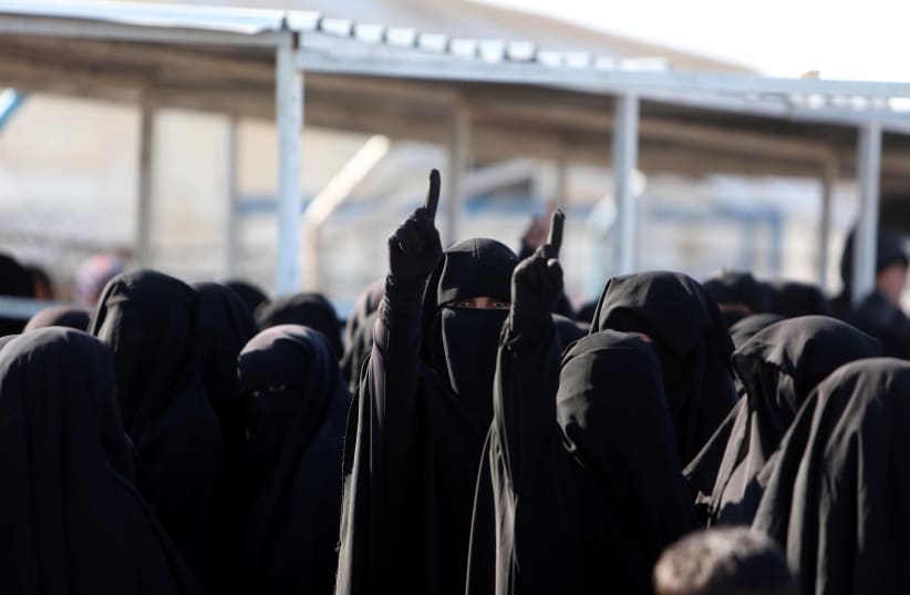 Women gesture as they stand together al-Hol displacement camp in Hasaka governorate, Syria, April 2, 2019. (photo credit: ALI HASHISHO/REUTERS)