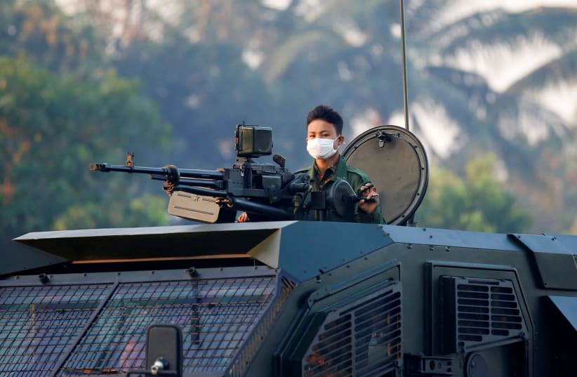 A soldier is seen on top of an armored vehicle believed to be made by Gaia Automotive Industres as he rolls through the streets of Naypyitaw, Myanmar, February 15, 2021.  (photo credit: REUTERS/STRINGER)