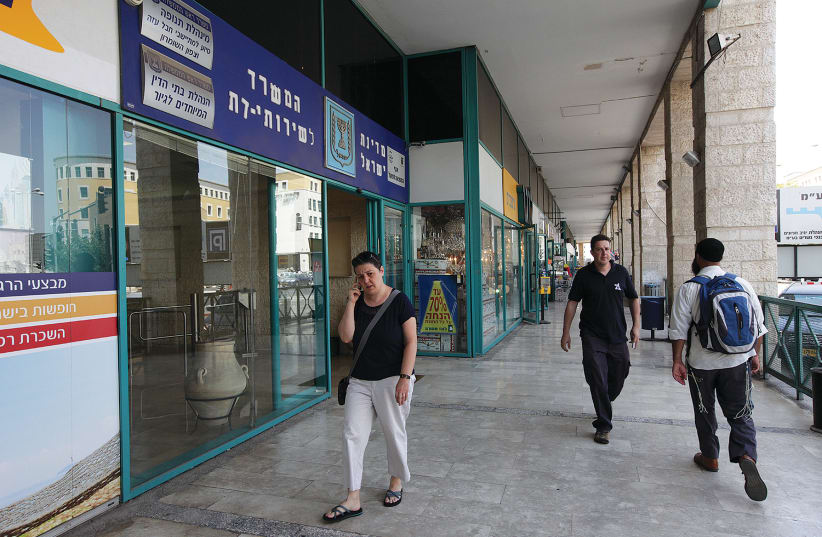 PEOPLE WALK past the Religious Services Ministry office in Jerusalem. At most, this week’s High Court ruling widens the scope of who can become an Israeli through immigration. (photo credit: MARC ISRAEL SELLEM/THE JERUSALEM POST)