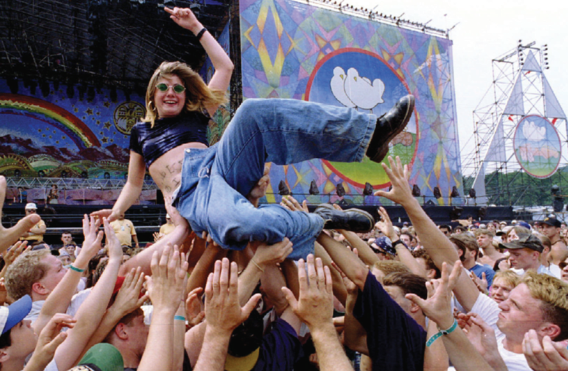Victoria Rose, 17, enjoys a ride across the crowd, Woodstock 1994. She lost her clothes crowd-surfing. (photo credit: REUTERS)