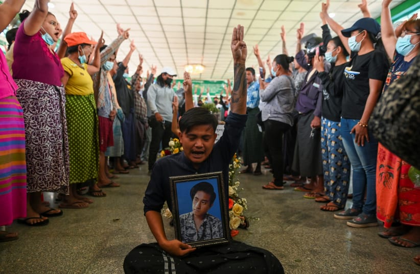 People flash a three-finger salute as they attend the funeral of victims shot dead during the anti-coup protest in Yangon, Myanmar, March 5, 2021. (photo credit: STRINGER/ REUTERS)