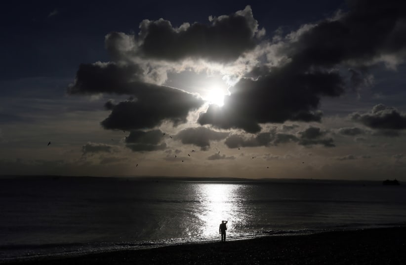 A man looks out to sea in Portsmouth (photo credit: STEFAN WERMUTH/REUTERS)