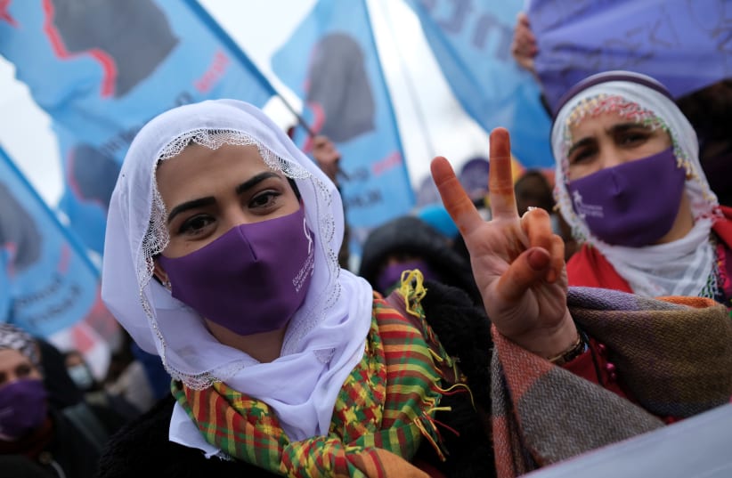 A demonstrator wearing a face mask to prevent the spread of the coronavirus disease (COVID-19) flashes the V sign during a rally ahead of the International Women's Day in Istanbul, Turkey March 6, 2021 (photo credit: REUTERS/MURAD SEZER)