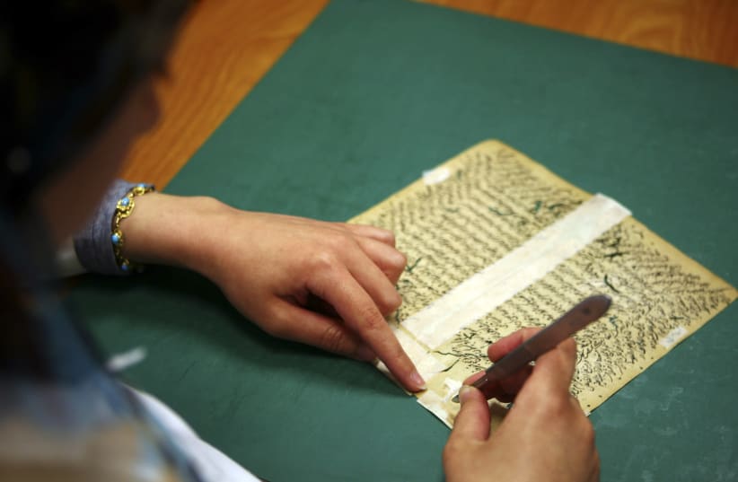 An Egyptian librarian fixes a rare book in the Restoration Laboratory in Alexandria Library (photo credit: REUTERS)