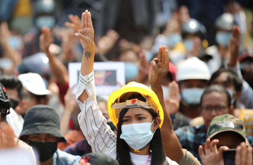 A woman shows a three-finger salute during a protest against the military coup in Naypyitaw (photo credit: REUTERS)
