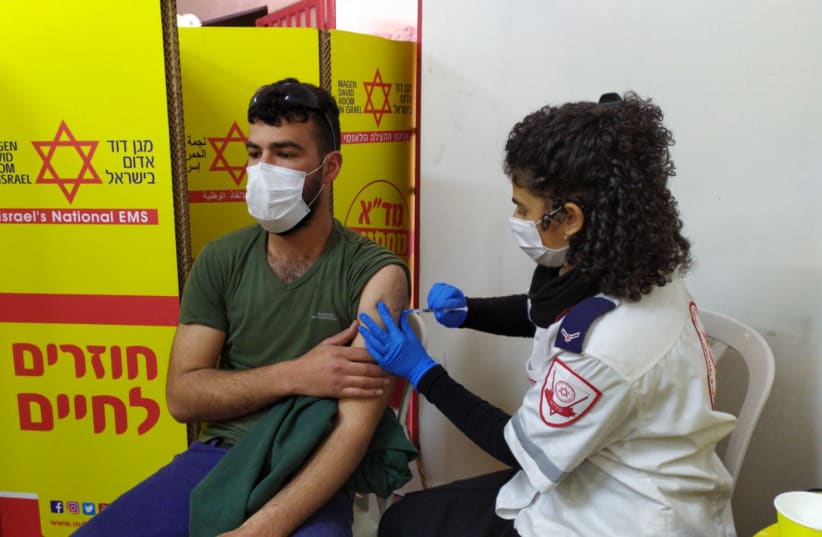 A Palestinian worker is given the coronavirus vaccine by Magen David Adom. (photo credit: MAGEN DAVID ADOM)