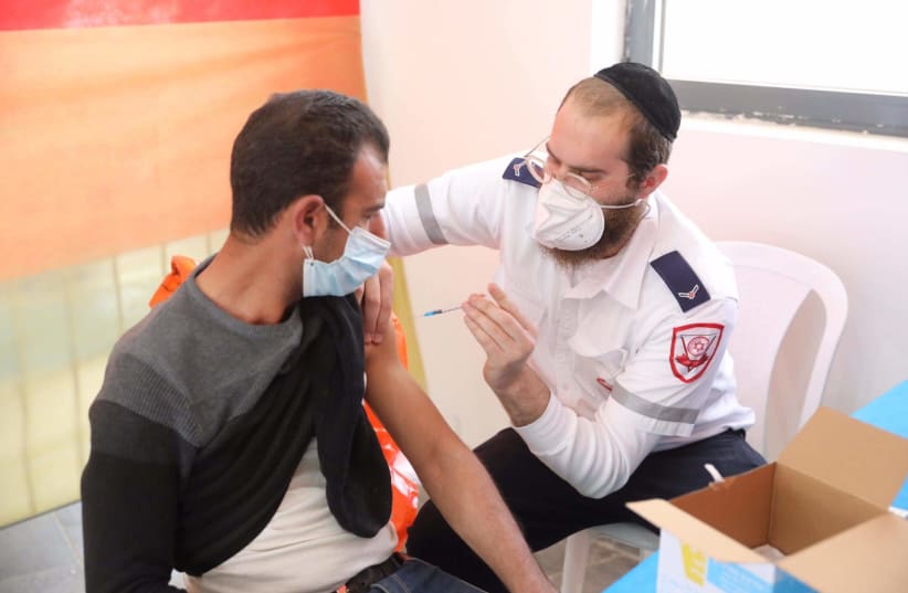 Palestinians receive the vaccine in a joint operation run by the Office of the Coordinator of the Government Activities in the Territories (COGAT), the Health Ministry and Magen David Adom that began on March 2nd 2021. (photo credit: MARC ISRAEL SELLEM)