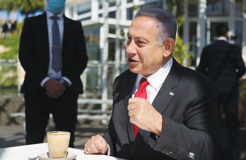 PRIME MINISTER Benjamin Netanyahu grabs a cup of coffee in Jerusalem this week. (photo credit: RONEN ZVULUN/REUTERS)