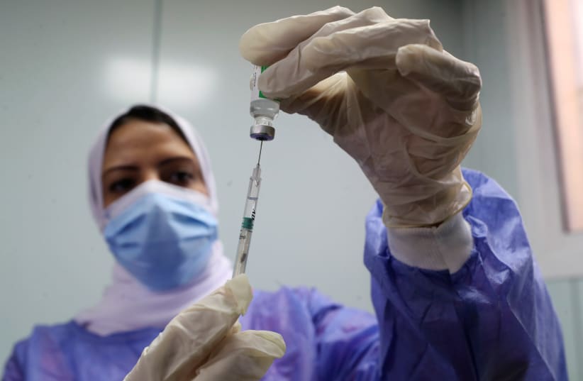 A healthcare worker holds a syringe and vaccine vial against the coronavirus disease (COVID-19) in Cairo, Egypt March 4, 2021. (photo credit: REUTERS/MOHAMED ABD EL GHANY)