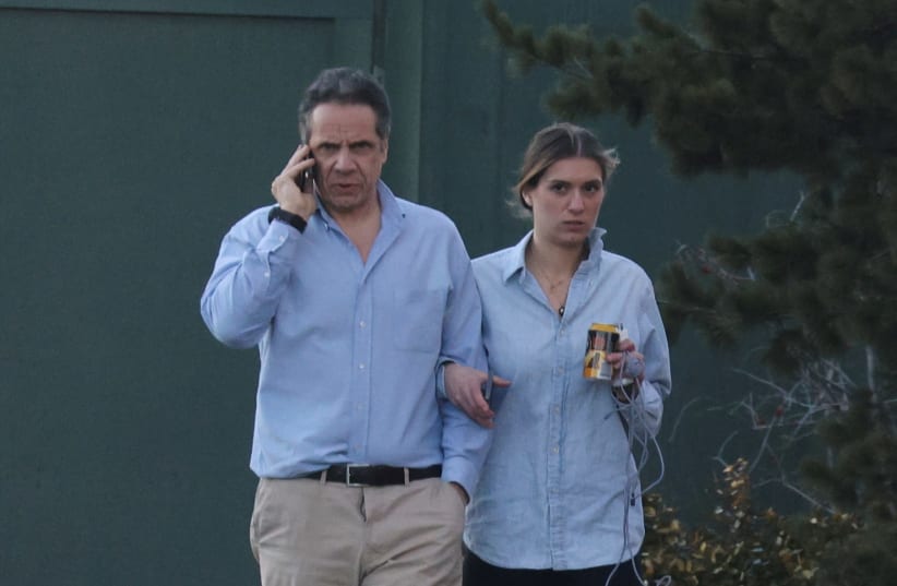 New York Governor, Andrew Cuomo, walks with his daughter on the grounds of the Governor's Mansion following allegations that he had sexually harassed young women, in Albany, New York, U.S., March 12, 2021. (photo credit: ANGUS MORDANT/ REUTERS)
