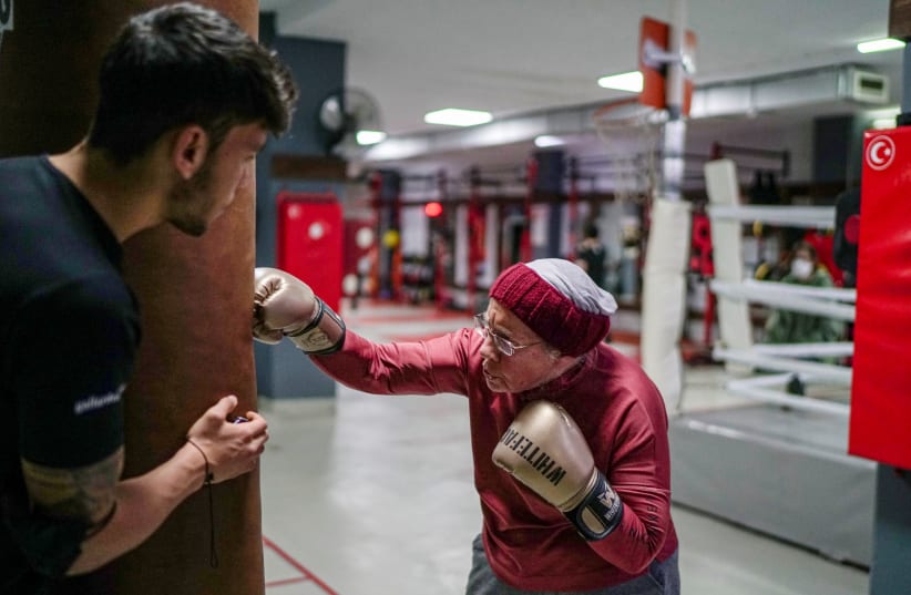 Nancy Van Der Stracten, 75-year-old suffering from Parkinson's disease, practices boxing with her trainer Muhammed Ali Kardas at a boxing club in the southern resort city of Antalya, Turkey, February 26, 2021.  (photo credit: UMIT BEKTAS / REUTERS)