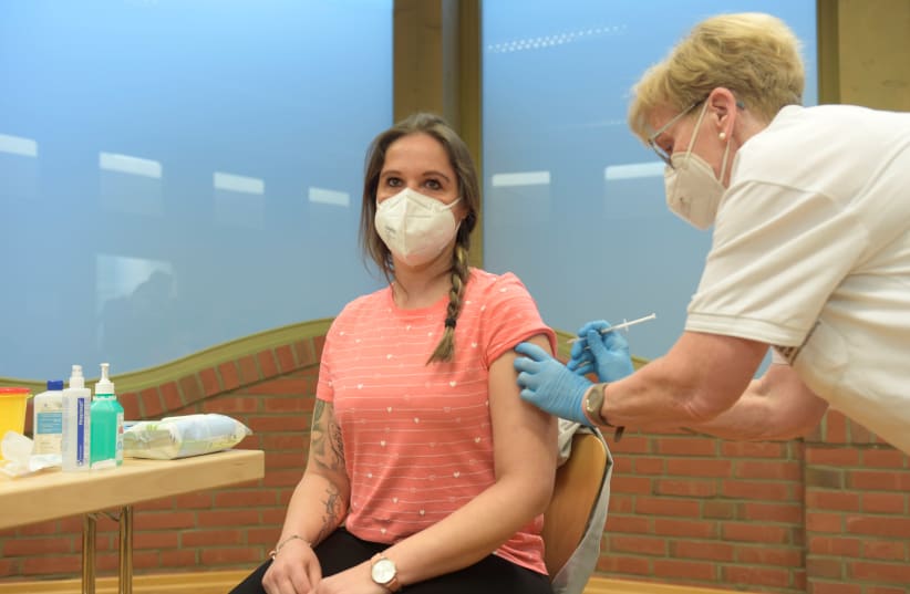 Nursery teacher, Kathy Wienecke, receives her first dose of AstraZeneca's COVID-19 vaccine from nurse Susanne Kugel, amid the spread of the coronavirus disease (COVID-19), in Grevesmuehlen, Germany, March 5, 2021.  (photo credit: REUTERS/FABIAN BIMMER)