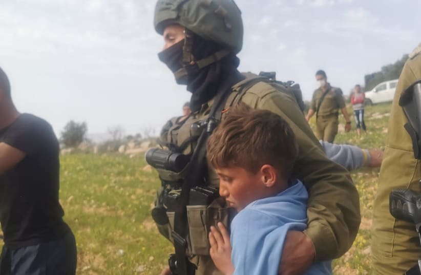 IDF soldiers detain Palestinian children near Havat Maon in the West Bank, March 10, 2021. (photo credit: NASSR NAWAJ'AH B'TSELEM)