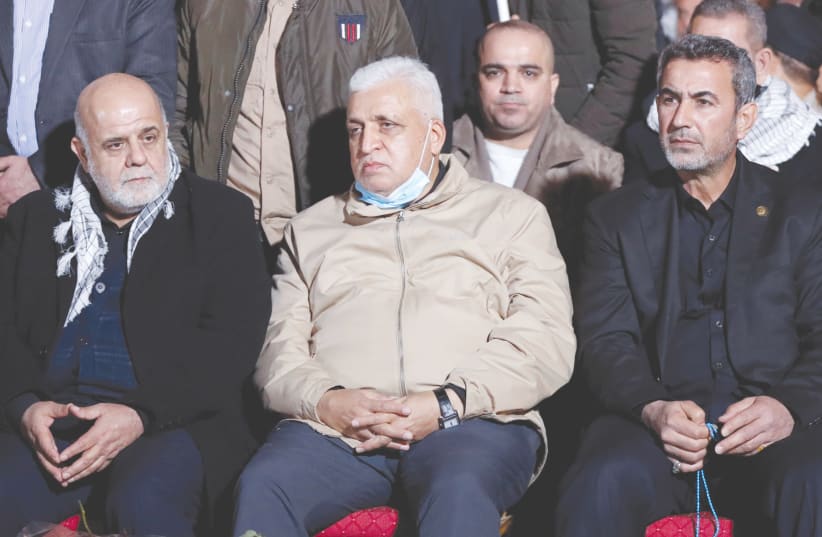 RAQI MILITIA head Faleh al-Fayyad, Deputy Commander Abdul Azizi Al-Mohammedawi, and Iranian Ambassador Iraj Masjedi mark the first anniversary of the killing of Qassem Soleimani and Abu Mahdi al-Muhandis, in Baghdad, Iraq, in January. (photo credit: THAIER AL-SUDANI/REUTERS)