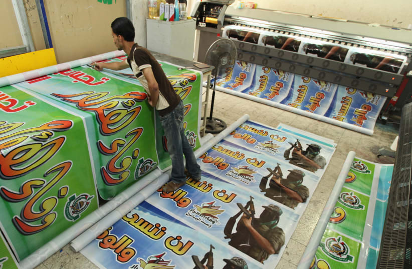 A Palestinian prints posters in preparation for a prisoner swap between Hamas and Israel in Gaza, 2011 (photo credit: MOHAMMED SALEM/ REUTERS)