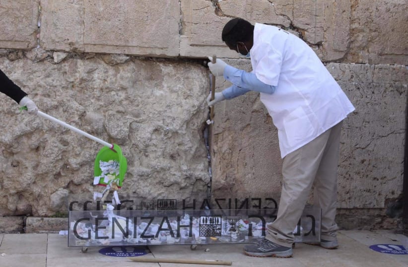 Notes in the Western Wall are cleared before Passover, 2021 (photo credit: MARC ISRAEL SELLEM)