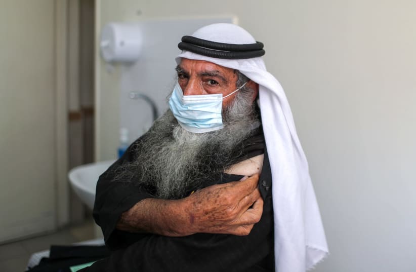 A Palestinian man waits to be vaccinated against the coronavirus disease (COVID-19), in Gaza City (photo credit: REUTERS)