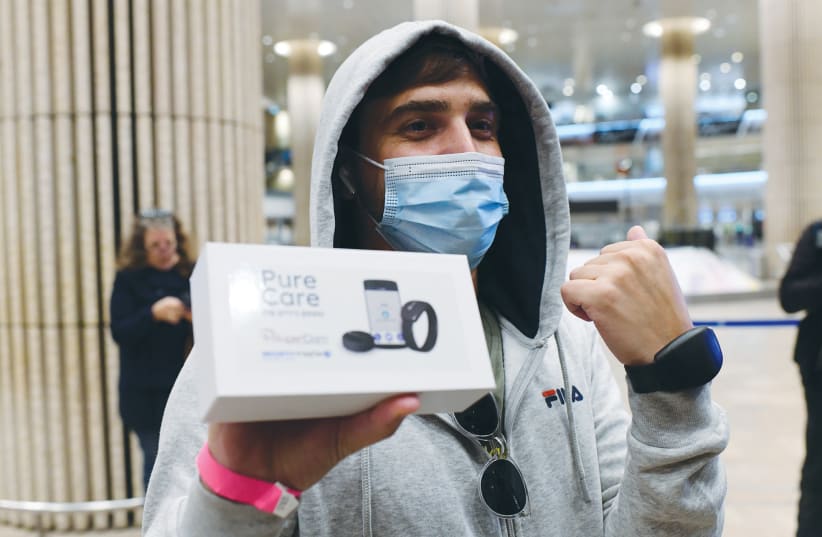 PASSENGERS ARRIVING from Frankfurt earlier this month receive electronic bracelets for their quarantine period.  (photo credit: TOMER NEUBERG/FLASH90)