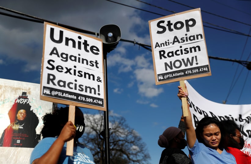 Demonstrators hold signs during a demonstration following the deadly shootings in Atlanta, Georgia, U.S. March 18, 2021.  (photo credit: SHANNON STAPLETON / REUTERS)