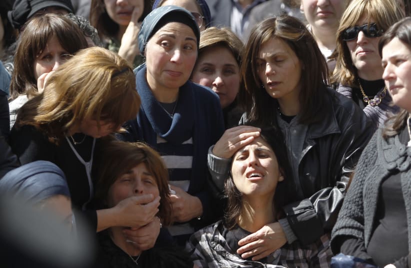 A relative of Miriam Monsonego mourns during funeral in Jerusalem (photo credit: REUTERS)