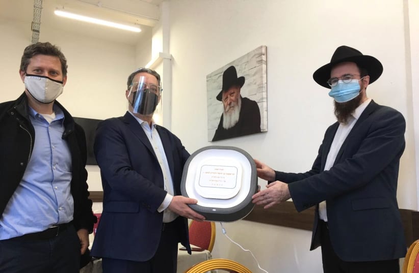 Installation of Covid-19 Air Purifiers at Golders Green Chabad House located in London, with the presence of Rabbi Shneor Glitzstein (R), Eyal Landau, and Sagi Barkai. (photo credit: AURA AIR)