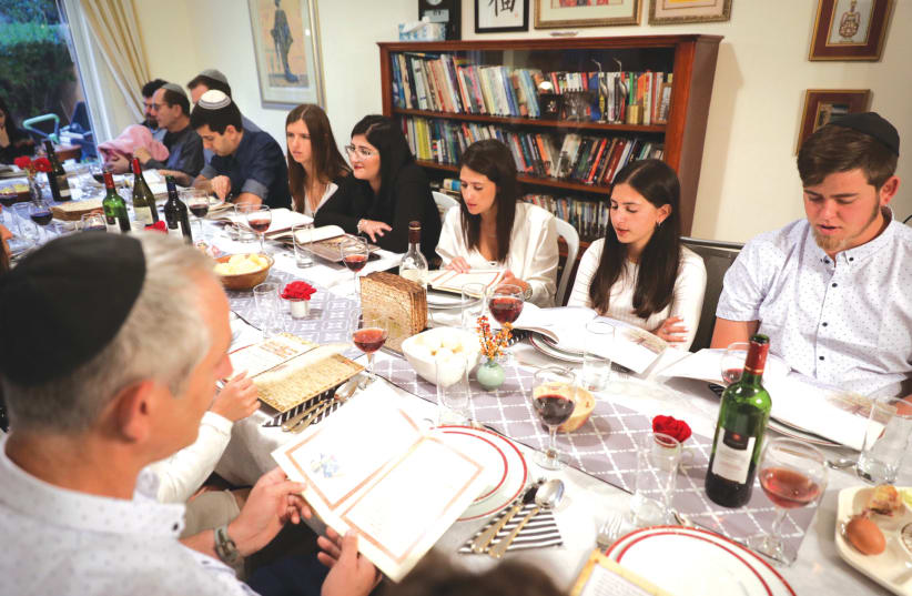A FAMILY gathers for their Seder on the first night of Passover, in Rishon Lezion, in 2018.  (photo credit: NATI SHOHAT/FLASH90)