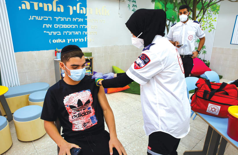 A STUDENT receives a COVID-19 vaccination at Amal High School in Beersheba last week. (photo credit: FLASH90)