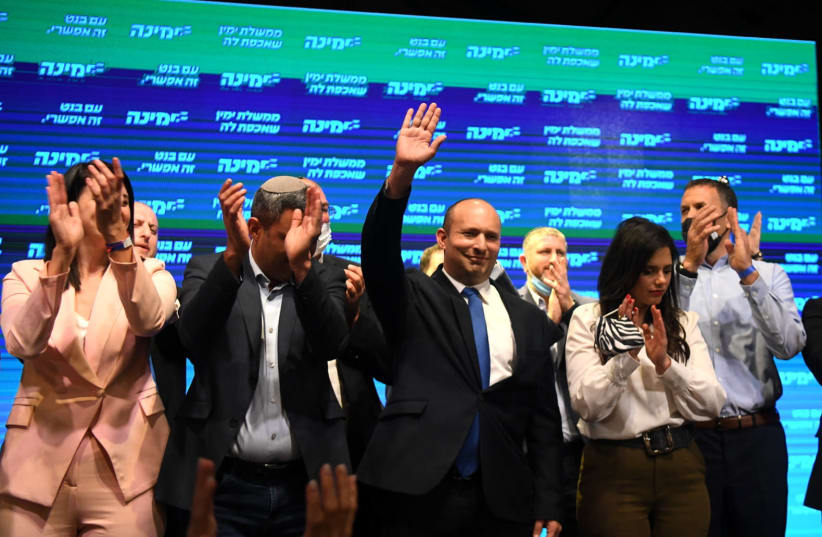 Naftali Bennett and party members are seen with Yamina supporters at the party headquarters in Petah Tikva, on elections night, on March 23, 2021. (photo credit: AVI DISHI/FLASH90)