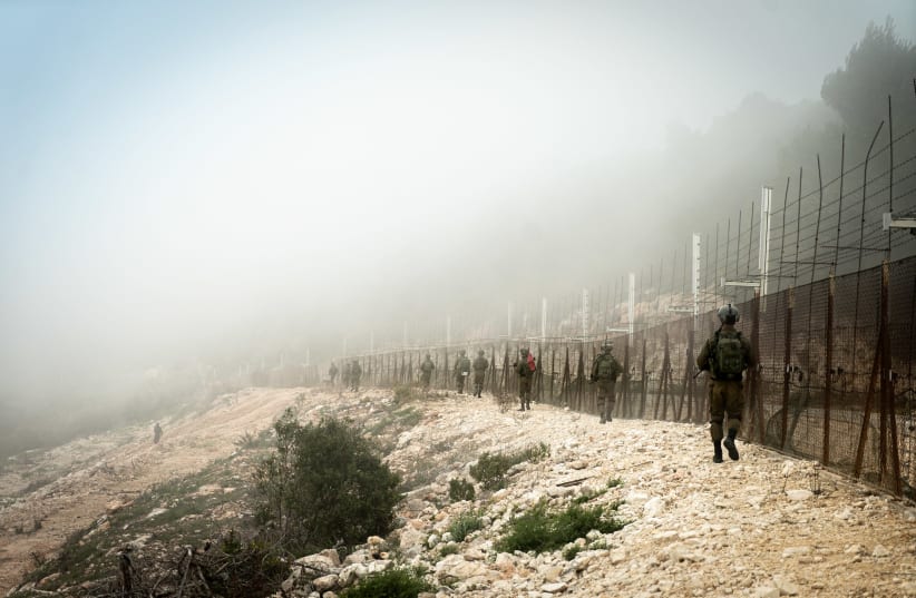 IDF SOLDIERS seen walking in the  enclave, near the fence. (photo credit: IDF SPOKESPERSON'S UNIT)
