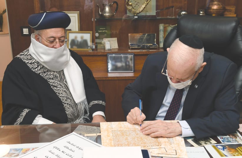 PRESIDENT REUVEN RIVLIN greets  and signs a document appointing Sephardi Chief Rabbi of Jerusalem Shlomo Moshe Ameras his agent in the sale of leave (photo credit: MARK NEYMAN/GPO)