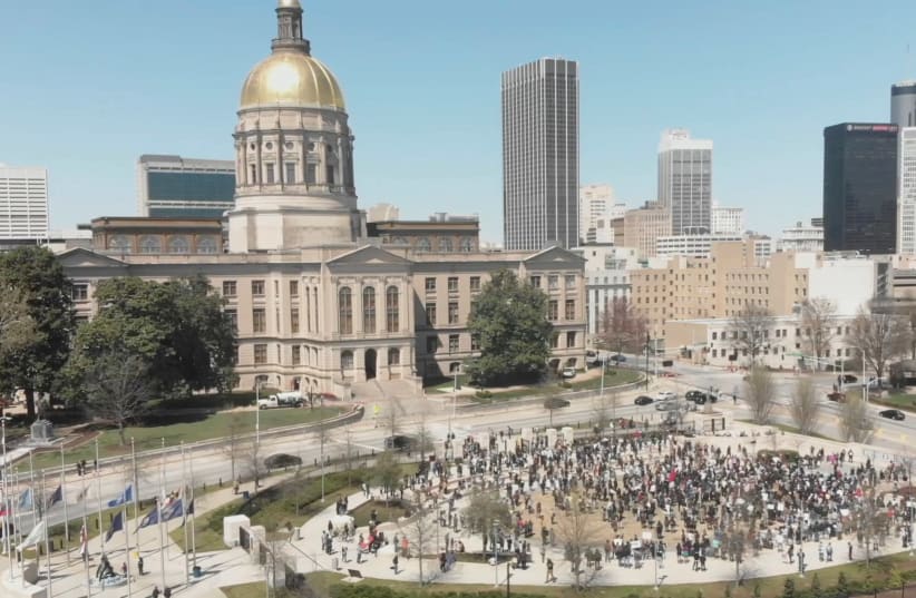 People participate in a Stop Asian Hate rally at Liberty Plaza, next to the Georgia State Capitol, in Atlanta, Georgia, March 20, 2021, in this still image from drone video obtained via social media. (photo credit: ARRHYTHMIA FILMS VIA REUTERS)