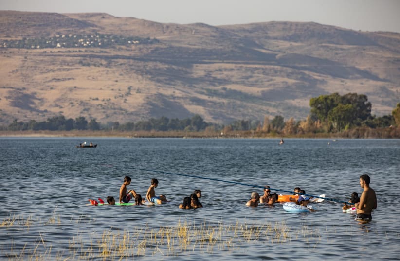 People enjoy and bath in the Sea of Galilee (Kinneret) next to the city of Tiberias on June 23, 2015.   (photo credit: OLIVIER FITOUSSI/FLASH90)
