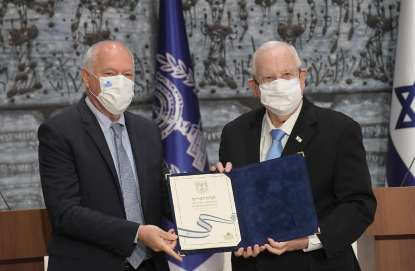 President Reuven Rivlin (R) receives the official election results from head of the Central Elections Committee, Supreme Court Judge Uzi Vogelman, March 31, 2021 (photo credit: AMOS BEN-GERSHOM/GPO)