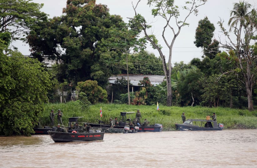 Venezuelan soldiers patrol by boat on the Arauca River, the border between Colombia and Venezuela, as seen from Arauquita, Colombia, March 28, 2021. (photo credit: REUTERS/LUISA GONZALEZ/FILE PHOTO)