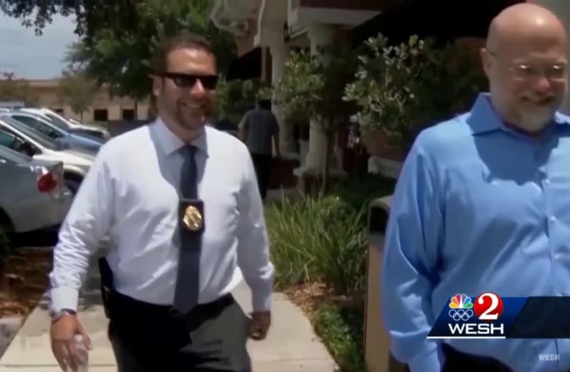 Joel Greenberg, bearing his tax collector badge and a sidearm, appears in a TV news report about his legal troubles in Seminole County, Florida, Jan. 25, 2021 (photo credit: YOUTUBE SCREENSHOT/JTA)