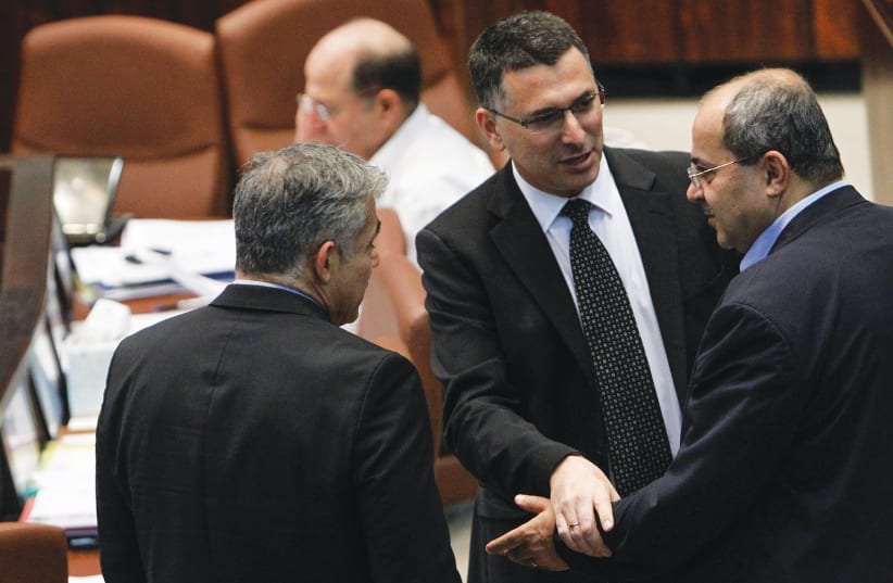 THEN-INTERNAL affairs minister Gideon Sa’ar (center) speaks with Arab parliament member Ahmad Tibi (right) and then-finance minister Yair Lapid during a plenum session in the Knesset in 2013. (photo credit: MIRIAM ALSTER/FLASH90)