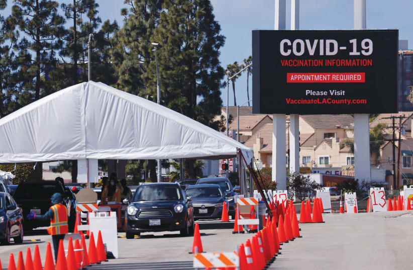 RESIDENTS OF Inglewood, California, receive COVID-19 vaccinations at a temporary vaccine station last month. (photo credit: MIKE BLAKE/ REUTERS)