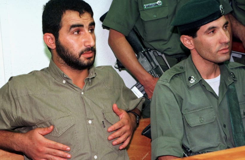 Hassan Salameh, a top member of the Hamas Islamic group, sits back under armed guard on the defendant's bench in an Israeli army military court as he waits to be sentenced July 7. Salameh, convicted of masterminding three Hamas suicide bombings last year which left 45 people dead, was sentenced to 4 (photo credit: REUTERS)