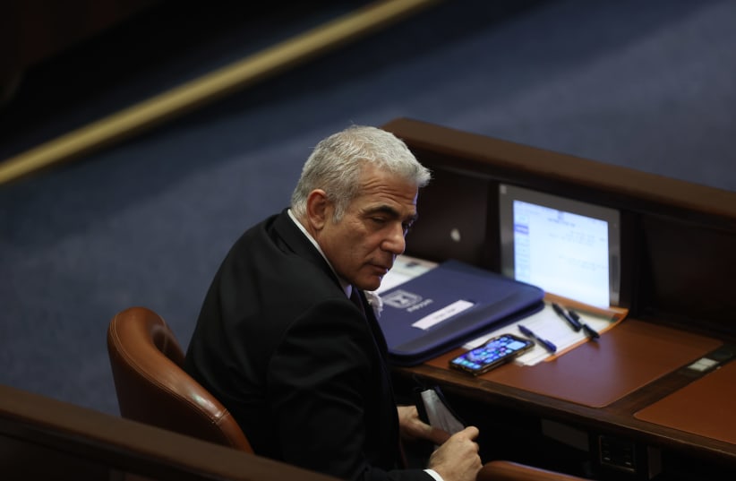 Yesh Atid leader Yair Lapid is seen in in the plenum during the inauguration of the 24th Knesset, on April 6, 2021. (photo credit: ALEX KOLOMOISKY/YEDIOT AHARONOT/POOL)