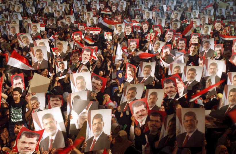 MUSLIM BROTHERHOOD members and supporters of Egyptian president Mohamed Mursi display his photo at Cairo’s Raba El-Adwyia mosque square, July 2013.  (photo credit: KHALED ABDULLAH/FILE PHOTO/REUTERS)