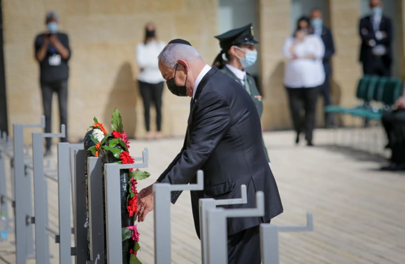Israeli Prime Minister Benjamin Netanyahu lay a wreath during a ceremony held at the Yad Vashem Holocaust Memorial Museum in Jerusalem, as Israel marks annual Holocaust Remembrance Day. April 8, 2021.  (photo credit: ALEX KOLOMOISKY / POOL)