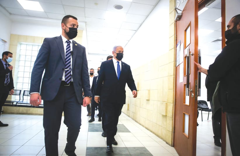 Prime Minister Benjamin Netanyahu makes his way into court on Monday. (photo credit: OREN BEN HAKOON/POOL)