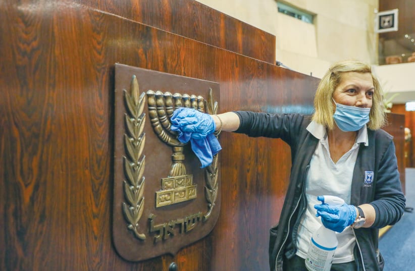 A WOMAN polishes the national symbol at the Knesset ahead of the inauguration ceremony this week. (photo credit: MARC ISRAEL SELLEM/THE JERUSALEM POST)